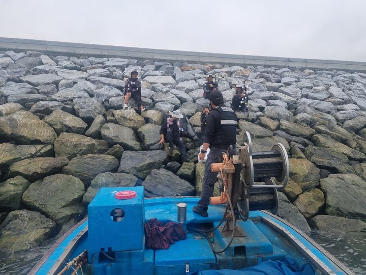 [서산=뉴시스] 태안해경이 4일 오후 5시5분께 충남 서산시 부석면 간월도 선착장 인근 방파제에 고립된 낚시객 5명을 민간어선을 이용해 구조하고 있다. (사진=태안해양경찰서 제공) 2025.10.04. photo@newsis.com *재판매 및 DB 금지