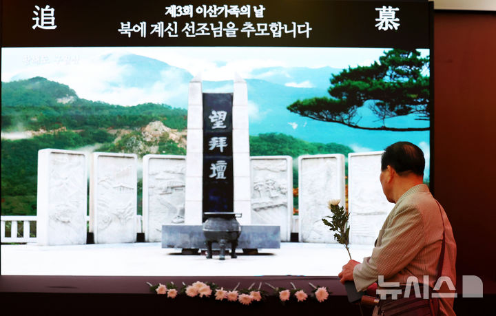 [서울=뉴시스] 홍효식 기자 = 4일 오전 서울 중구 더 플라자 호텔에서 열린 제3회 이산가족의 날 기념식에 앞서 한 참석자가 디지털 망배단에 북에 계신 선조들을 기리며 헌화하고 있다. 2025.10.04. yesphoto@newsis.com