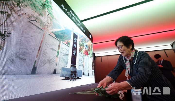 [서울=뉴시스] 홍효식 기자 = 4일 오전 서울 중구 더 플라자 호텔에서 열린 제3회 이산가족의 날 기념식에 앞서 한 참석자가 디지털 망배단에 북에 계신 선조들을 기리며 헌화하고 있다. 2025.10.04. yesphoto@newsis.com