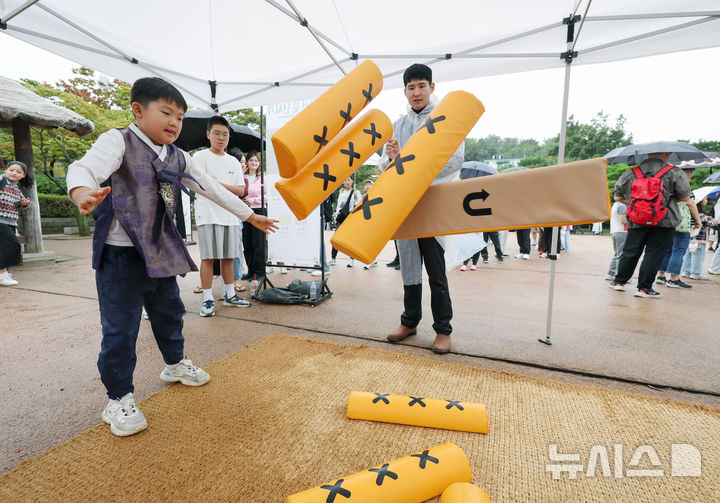 [서울=뉴시스] 김진아 기자 = 추석 연휴인 7일 서울 중구 남산골 한옥마을에서 열린 '추석놀이터'에서 한복을 입은 어린이들이 윷놀이를 하고 있다. 2025.10.07. bluesoda@newsis.com