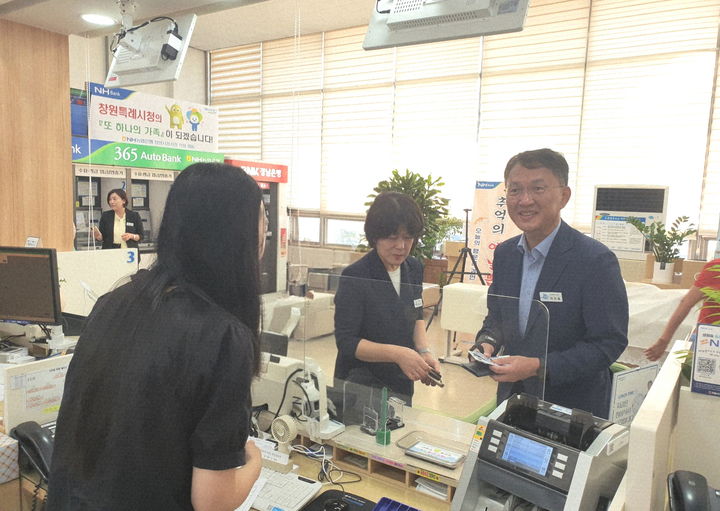 [창원=뉴시스] 강경국 기자 = 박진열 경남 창원시 경제일자리국장이 추석 명절을 앞두고 발행한 창원사랑상품권 '누비전'을 은행에서 구매하고 있다. (사진=창원시청 제공). 2025.10.08. photo@newsis.com *재판매 및 DB 금지
