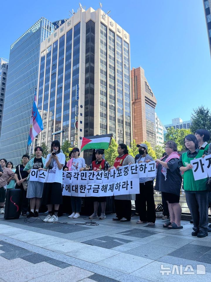 [서울=뉴시스]8일 오후 서울 중구 주한 이스라엘대사관 맞은편에서 열린 '가자 선단 나포 및 활동가 구금 규탄 기자회견'에서 참가자들이 피켓을 들고 발언하고 있다. 2025.10.08. (사진=강정친구들 제공)