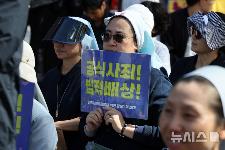 [서울=뉴시스] 배훈식 기자 = 제1721차 일본군 성노예제 문제 해결을 위한 정기 수요시위가 열린 8일 오후 서울 종로구 주한 일본대사관 인근에서 한 시위 참가자가 일본 정부의 공식 사과와 배상을 촉구하는 피켓을 들고 있다. 2025.10.08. dahora83@newsis.com