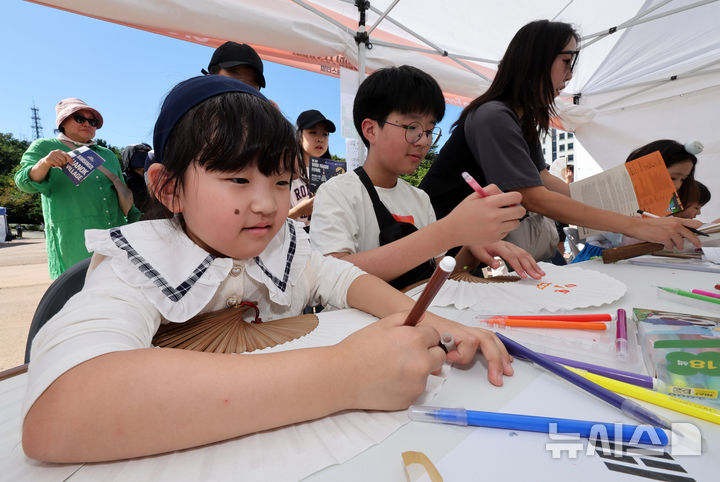 [서울=뉴시스] 배훈식 기자 = 제3회 월드판소리페스티벌이 개막한 8일 오후 서울 중구 남산골한옥마을을 찾은 아이들이 부채 만들기 체험을 하고 있다. 2025.10.08. dahora83@newsis.com
