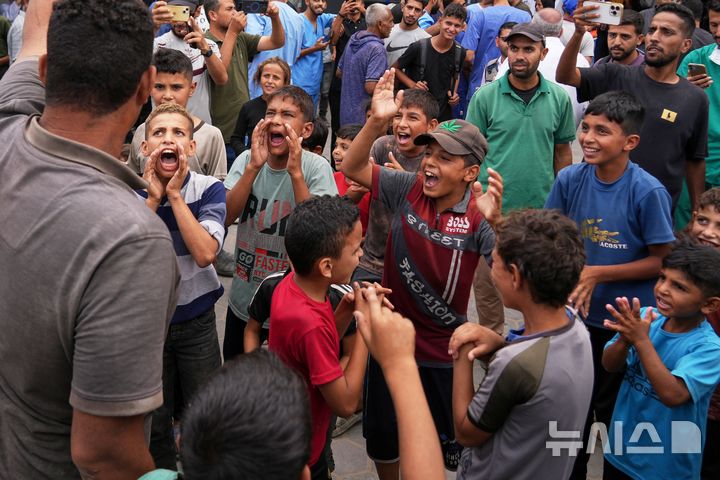 [AP/뉴시스] 미 트럼프 대통령에 의해 이스라엘과 하마스 간 휴전 합의 소식이 전해진 얼마 뒤인 9일 아침 가자 지구 팔레스타인 사람들이 휴전 성사에 기뻐하고 있다. 가자 중부 데이르 알발라의 알아크사 병원 모습이다. 