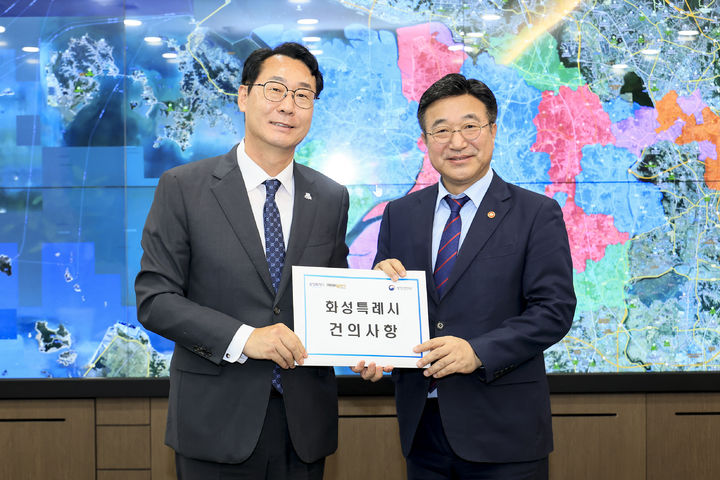 [화성=뉴시스] 더불어민주당 정명근 경기 화성시장 후보(왼쪽)가 지난 2025년 9월22일 화성시를 방문한 윤호중 행정안전부장관에서 건의사항을 전달하며 기념촬영을 하고 있다. (사진=뉴시스 DB). photo@newsis.com *재판매 및 DB 금지