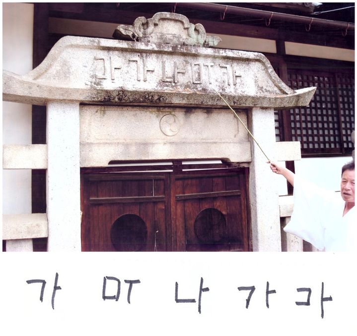 [울산=뉴시스] 나가오 신사 신문(神門)은 사람은 출입하지 않는다며 출입 시 신이 노한다고 적힌 석문(石文)을 후쿠다(福田) 신주(神主)가 설명하고 있다. 사진 아래쪽 '가 ㅁㅜ'는 일본 신(神)이란 뜻이고 '나 가 라'는 신(神)이 존재한다는 뜻의 한글이다. ㄷ은 거꾸로 쓴 것이다. (사진=김문길 소장 제공) 2025.10.09. photo@newsis.com *재판매 및 DB 금지