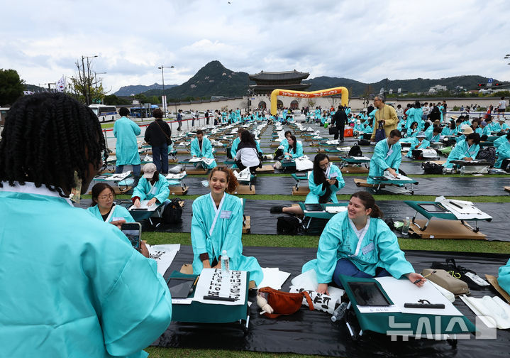 [서울=뉴시스] 최진석 기자 = 579돌 한글날인 9일 오전 서울 광화문광장에서 열린 광화문광장 휘호대회에 참가한 외국인들이 기념촬영하고 있다. 2025.10.09. myjs@newsis.com