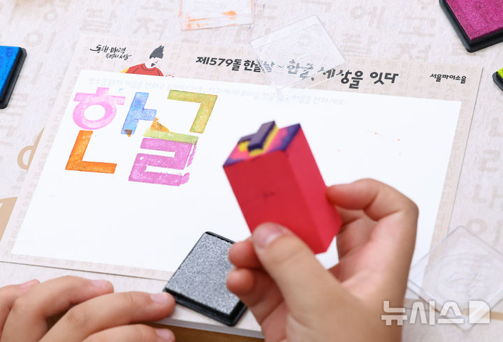 [서울=뉴시스] 최진석 기자 = 579돌 한글날인 9일 오전 서울 광화문광장에서 열린 한글, 세상을 잇다 행사에서 어린이들이 우리글멋글씨 체험을 하고 있다. 2025.10.09. myjs@newsis.com