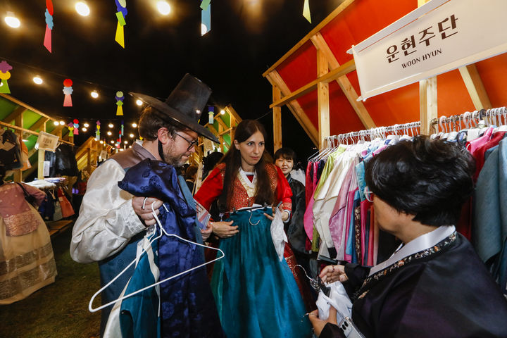 [서울=뉴시스] 8일 경복궁에서 열린 '한복 연향'의 한복 상인과 협업한 팝업스토어 '한복! 데려가세요!'에서 외국인 관람객들이 한복을 입고 사진 촬영을 하고 있다. (사진=국가유산진흥원 제공) 2025.10.10. photo@newsis.com *재판매 및 DB 금지