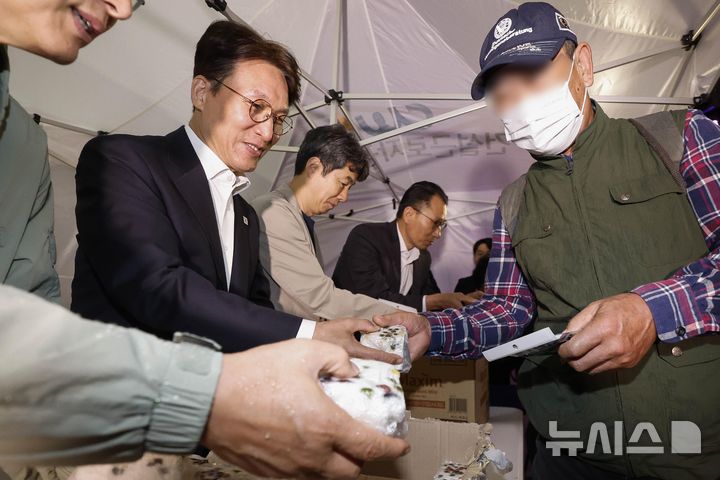 [서울=뉴시스] 청사사진기자단 = 김민석 국무총리가 10일 서울 구로구 남구로역 인근 인력시장을 방문해 건설 일용근로자들에게 간식과 팔토시 등 격려물품을 전달하고 있다. 2025.10.10. photo@newsis.com