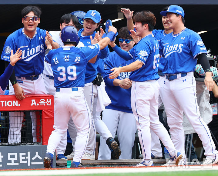 [서울=뉴시스] 박주성 기자 = 11일 인천 미추홀구 SSG랜더스필드에서 열린 2025 KBO 포스트시즌 준플레이오프 2차전 삼성 라이온즈와 SSG 랜더스의 경기, 4회초 원아웃 주자 2, 3루에서 삼성 디아즈의 2타점 적시타 때 홈을 밟은 김성윤이 팀 동료와 기쁨을 나누고 있다. 2025.10.11. park7691@newsis.com