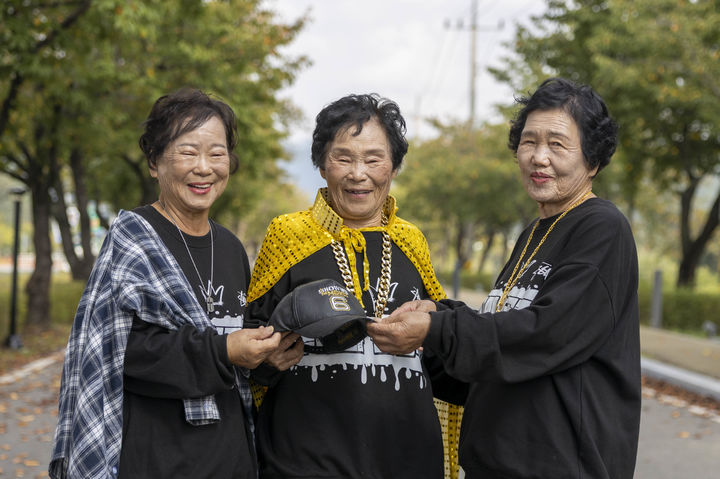 [칠곡=뉴시스] 수니와칠공주 맴버들이 레퍼 슬리피의 모자를 들고 있다. (사진=칠곡군 제공) 2025.10.12 photo@newsis.com *재판매 및 DB 금지