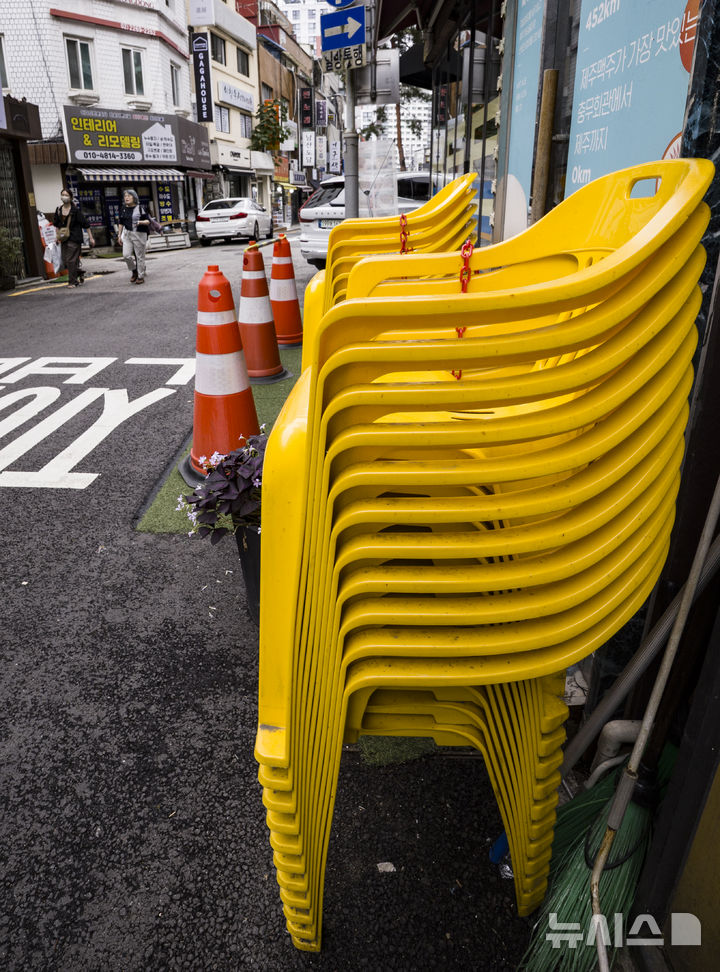 [서울=뉴시스] 김근수 기자 = 12일 서울 시내의 한 음식점 앞에 빈 의자가 놓여 있다. 한국은행이 국회 행정안전위원회에 제출한 '자영업자 대출 현황' 자료에 따르면 올해 2분기(기말 기준) 자영업자의 전체 금융기관 대출 잔액은 1천69조6천억원으로 추산됐다. 자영업자 대출은 1분기 말(1천67조6천억원)과 비교해 불과 3개월 사이 2012년 관련 통계 집계 이래 최대를 기록했다. 자영업자 대출을 종류별로 나눠보면 사업자 대출이 723조3천억원, 가계대출이 346조3천억원을 차지했다. 사업자 대출 잔액 역시 2012년 통계 작성 이후 가장 많다. 2025.10.12. ks@newsis.com
