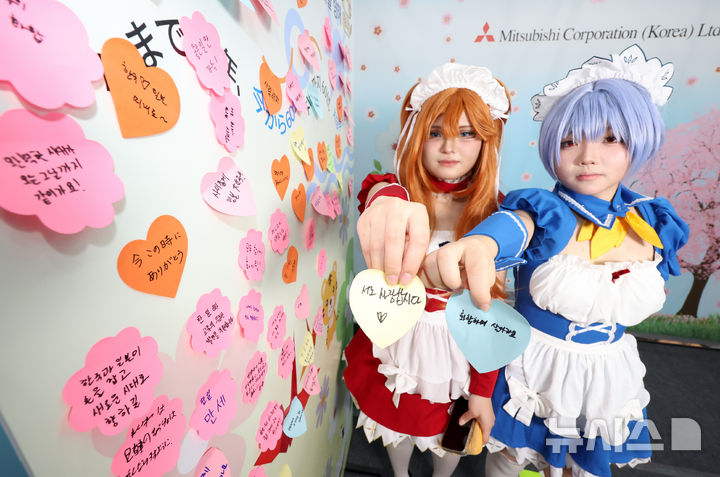 [서울=뉴시스] 조성우 기자 = 12일 서울 강남구 코엑스에서 열린 '제21회 한일축제한마당 2025 인 서울'을 찾은 코스프레 참여자가 메시지를 적은 포스트잇을 보여주고 있다. 2025.10.12. xconfind@newsis.com