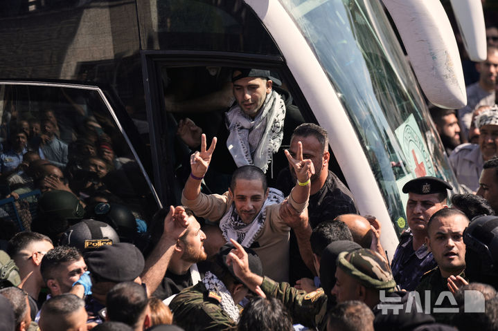 [AP/뉴시스] 13일 이스라엘 감옥에서 풀려난 팔레스타인 장기수가 서안지구 라말라 인근에 내리면서 승리 사인을 하고 있다 