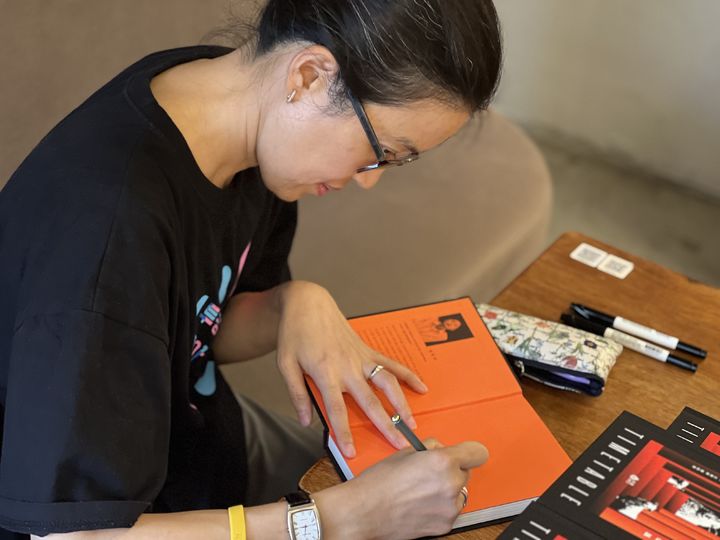 [서울=뉴시스] 정보라 작가가 '한밤의 시간표' 영미권 출간 기념 리미티드 스페셜 에디션에 사인하고 있다. (사진=퍼플레인 제공) 2025.10.13. photo@newsis.com *재판매 및 DB 금지