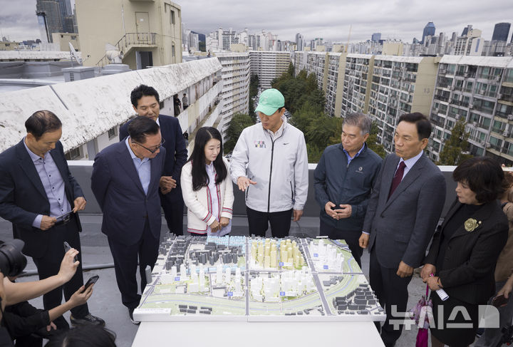 [서울=뉴시스] 김근수 기자 = 오세훈(가운데) 서울시장이 13일 서울 강남구 대치 은마아파트 재건축 현장에서 모형 도감을 살펴보고 있다. 2025.10.13. ks@newsis.com