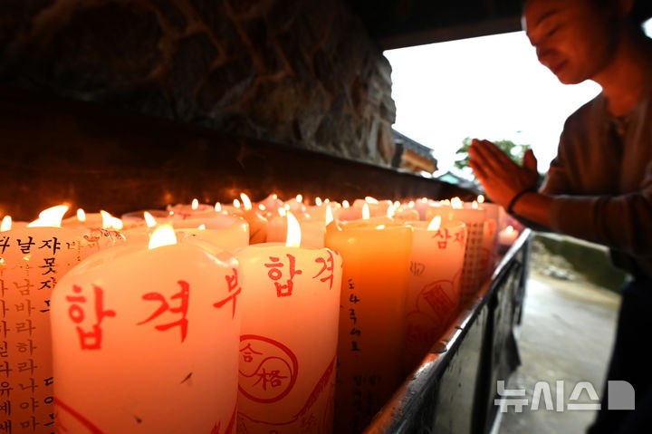 [화성=뉴시스] 김종택 기자 = 2026학년도 대학수학능력시험(11월13일)을 한달 앞둔 13일 경기 화성시 용주사에서 수험생 학부모가 자녀의 수능 고득점을 기원하며 촛불 앞에서 기도하고 있다. 2025.10.13. jtk@newsis.com