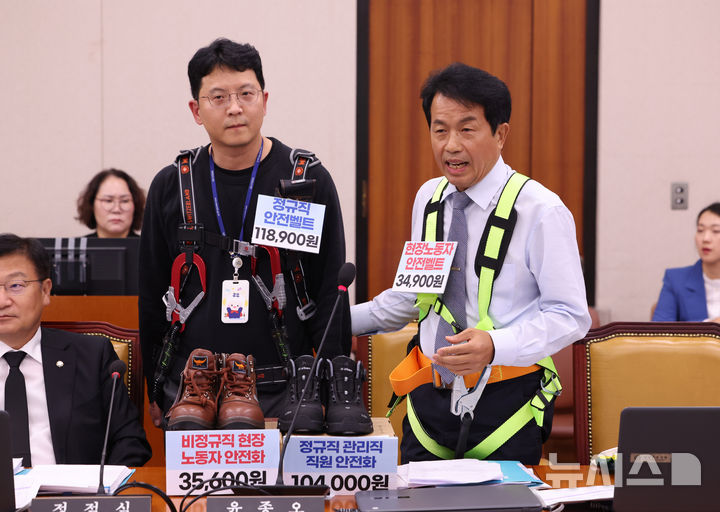 [서울=뉴시스] 김명년 기자 = 윤종오 진보당 의원이 13일 오후 서울 여의도 국회에서 열린 국토교통위원회 국정감사에서 김윤덕 국토교통부장관에게 질의 도중 정규직 관리직과 비정규직 현장노동자의 안전벨트를 직접 입고 비교하고 있다. 2025.10.13. kmn@newsis.com