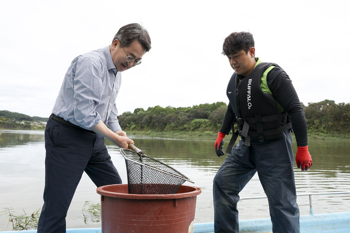 [수원=뉴시스] 김동연 경기도지사가 14일 연천을 찾아 '한탄강 청년어부' 김은범씨의 일을 돕고 있다. (사진=경기도 제공) 2025.10.14. photo@newsis.com *재판매 및 DB 금지