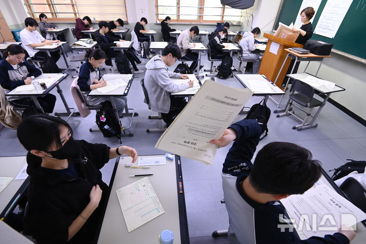 [수원=뉴시스] 김종택 기자 = 2026학년도 대학수학능력시험을 앞두고 마지막 모의고사인 전국연합학력평가가 실시된 14일 경기 수원시 효원고등학교에서 고3 수험생들이 문제지를 전달하고 있다. 2025.10.14. jtk@newsis.com