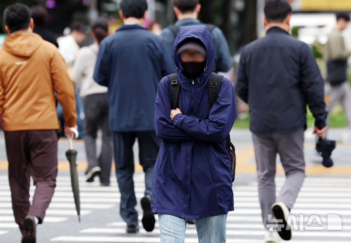[서울=뉴시스] 조성우 기자 = 비가 내리는 14일 오전 서울 종로구 세종대로 사거리에서 몸을 움츠린 한 시민이 이동하고 있다. 2025.10.14. xconfind@newsis.com