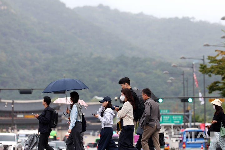 [서울=뉴시스] 조성우 기자 = 비가 내리는 전날 오전 서울 종로구 세종대로 사거리에서 우산을 든 시민들이 이동하고 있다. 2025.10.14. xconfind@newsis.com