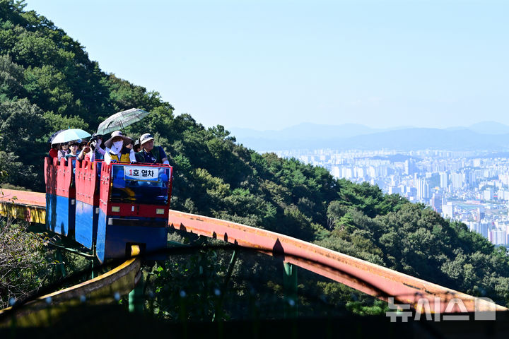 [광주=뉴시스] 이영주 기자 = 광주·전남이 화창한 날씨를 보인 11일 오전 광주 동구 지산유원지에서 관광객들이 모노레일을 타고 있다. 2025.10.11. leeyj2578@newsis.com