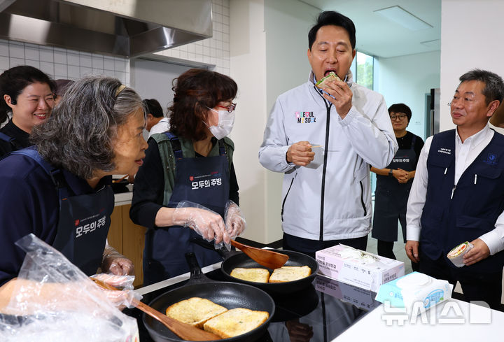 [서울=뉴시스] 박주성 기자 = 오세훈 서울시장이 14일 오후 서울 중구 해든센터에서 열린 남대문 쪽방촌 임대주택 '해든집' 입주 축하 행사에 참석해 공유주방에서 요리교실 수업 중인 주민들이 만든 샌드위치를 먹어보고 있다. 2025.10.14. park7691@newsis.com