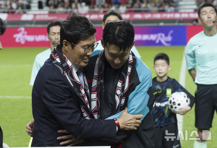[서울=뉴시스] 김근수 기자 = 한국 남자 선수 A매치 최다 출전한 손흥민이 14일 오후 서울 마포구 서울월드컵경기장에서 열린 하나은행 초청 축구국가대표팀 친선경기 대한민국과 파라과이의 경기 시작 전 차범근 전 감독에게 기념 유니폼을 전달받고 포옹을 하고 있다.손흥민은 지난 10일 브라질전에 개인 통산 137번째 A매치에 출전했다. 차범근 전 대표팀 감독, 홍명보 대표팀 감독(이상 136경기)을 제치고 한국 남자 축구 역사상 최다 출전 기록 보유자가 됐다. 2010년 12월 시리아전 데뷔 이후 15년 만이다. 2025.10.14. ks@newsis.com
