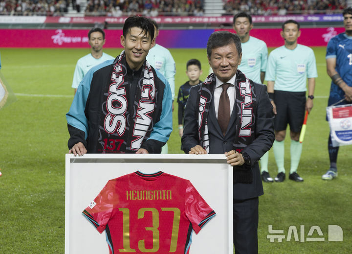[서울=뉴시스] 김근수 기자 = 한국 남자 선수 A매치 최다 출전한 손흥민이 14일 오후 서울 마포구 서울월드컵경기장에서 열린 하나은행 초청 축구국가대표팀 친선경기 대한민국과 파라과이의 경기 시작 기념 유니폼을 전달받고 정몽규 축구협회장과 기념촬영을 하고 있다.손흥민은 지난 10일 브라질전에 개인 통산 137번째 A매치에 출전했다. 차범근 전 대표팀 감독, 홍명보 대표팀 감독(이상 136경기)을 제치고 한국 남자 축구 역사상 최다 출전 기록 보유자가 됐다. 2010년 12월 시리아전 데뷔 이후 15년 만이다. 2025.10.14. ks@newsis.com