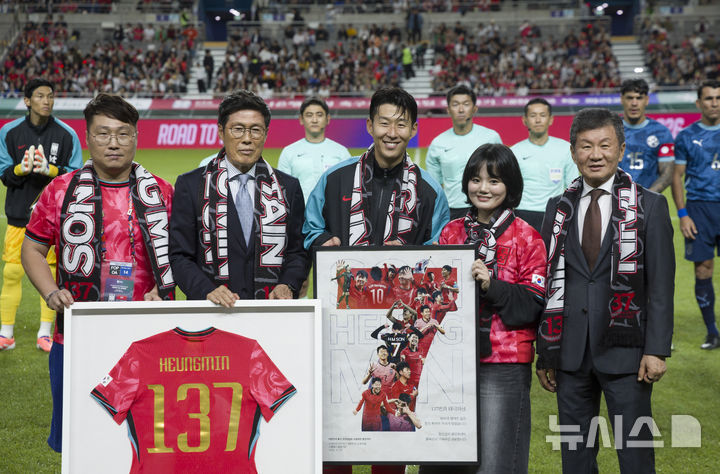 [서울=뉴시스] 김근수 기자 = 한국 남자 선수 A매치 최다 출전한 손흥민이 14일 오후 서울 마포구 서울월드컵경기장에서 열린 하나은행 초청 축구국가대표팀 친선경기 대한민국과 파라과이의 경기 시작 전 차범근 전 감독에게 기념 유니폼을 전달받고 기념촬영을 하고 있다.손흥민은 지난 10일 브라질전에 개인 통산 137번째 A매치에 출전했다. 차범근 전 대표팀 감독, 홍명보 대표팀 감독(이상 136경기)을 제치고 한국 남자 축구 역사상 최다 출전 기록 보유자가 됐다. 2010년 12월 시리아전 데뷔 이후 15년 만이다. 2025.10.14. ks@newsis.com