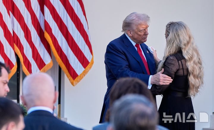 [워싱턴=AP/뉴시스] 도널드 트럼프 미국 대통령이 14일(현지 시간) 미 워싱턴 백악관 로즈가든에서 열린 찰리 커크 대통령 자유의 메달 수여식에서 커크의 부인 에리카 커크를 위로하고 있다. 2025.10.15.