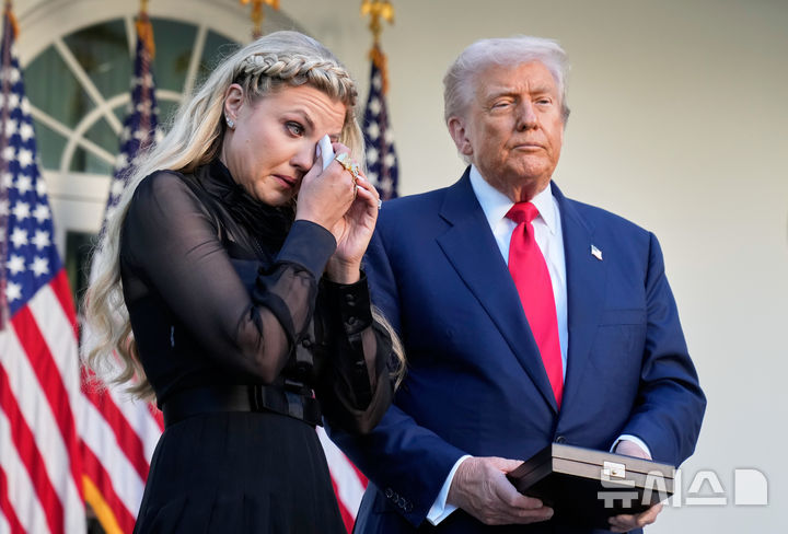 [워싱턴=AP/뉴시스] 도널드 트럼프 미국 대통령이 14일(현지 시간) 미 워싱턴 백악관 로즈가든에서 열린 찰리 커크 대통령 자유의 메달 수여식에서 커크의 부인 에리카 커크를 위로하고 있다. 2025.10.15.