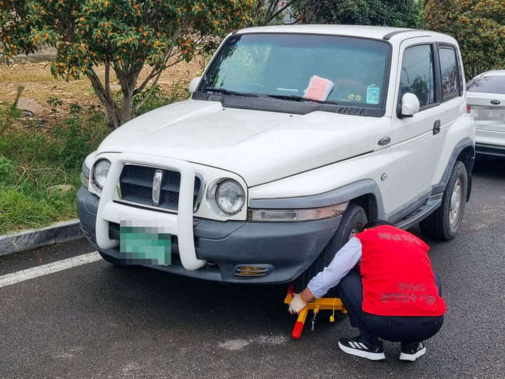 [창녕=뉴시스] 창녕군이 체납 차량 바퀴잠금장치(족쇄) 부착하고 있다. (사진= 창녕군 제공) 2025.10.15. photo@newsis.com *재판매 및 DB 금지