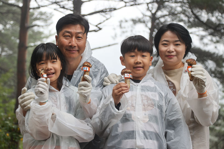 [양양=뉴시스] 양양송이축제 대표 프로그램인 ‘송이보물찾기’에 참여한 한 가족이 송이를 들고 기념사진을 찍고 있다.(사진=양양군 제공)photo@newsis.com *재판매 및 DB 금지