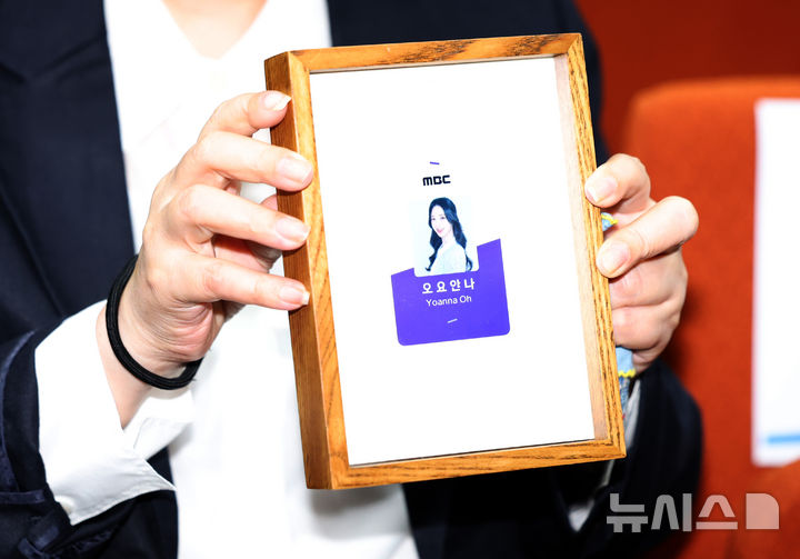 [서울=뉴시스] 이영환 기자 = 고 오요안나씨 어머니 장연미씨가 15일 오전 서울 마포구 MBC에서 열린 고 오요안나 1주기 관련 대국민 기자회견에서 고인의 명예사원증을 들고 있다. 2025.10.15. 20hwan@newsis.com