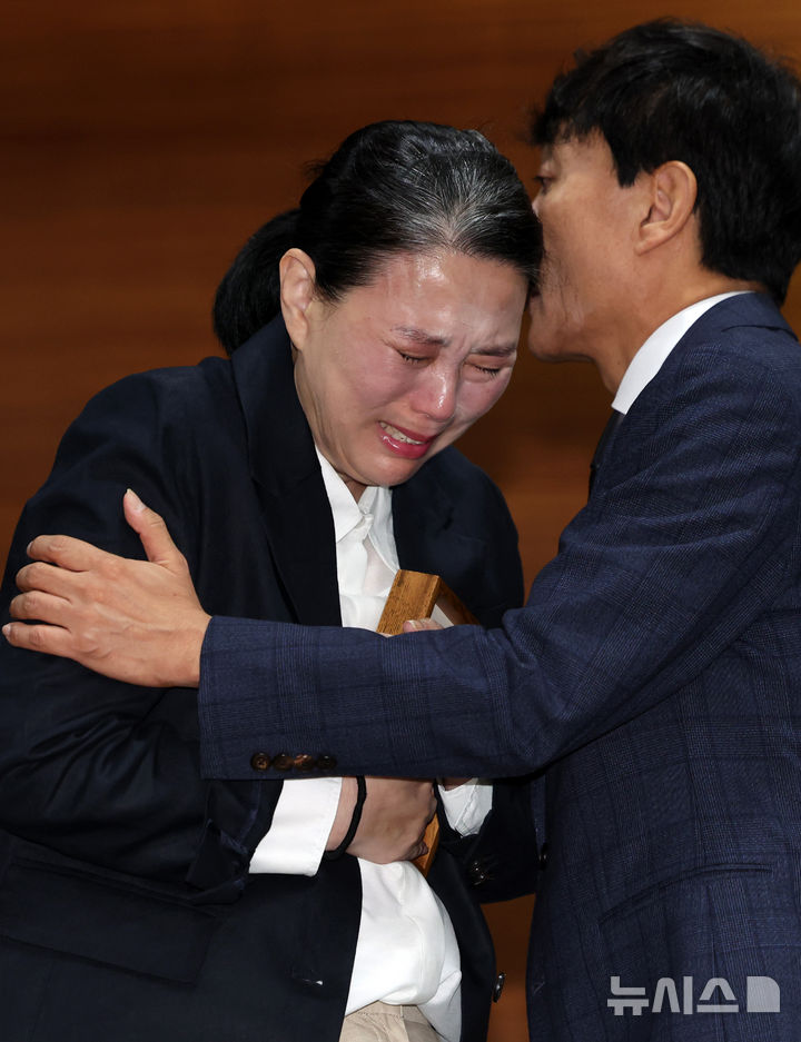 [서울=뉴시스] 이영환 기자 = 고 오요안나씨 어머니 장연미씨가 15일 오전 서울 마포구 MBC에서 열린 고 오요안나 1주기 관련 대국민 기자회견에서 안형준(오른쪽) MBC 사장에게 명예사원증을 전달 받은 후 슬퍼하고 있다. 2025.10.15. 20hwan@newsis.com