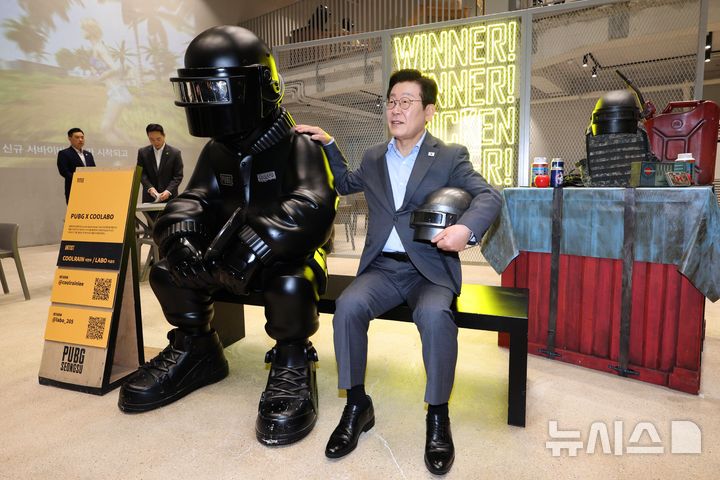 [서울=뉴시스] 고범준 기자 = 이재명 대통령이 15일 서울 성동구 펍지 성수에서 열린 K-게임 현장 간담회에서 게임 '배틀 그라운드' IP를 활용한 공간 관람을 하고 있다. 2025.10.15. bjko@newsis.com