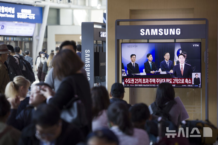 [서울=뉴시스] 김근수 기자 = 정부가 10·15 부동산 대책을 발표한 15일 오전 서울역 대합실 텔레비전에 관련 뉴스가 나오고 있다.정부가 6·27 대출 규제과 9·7공급대책에 이어 발표한 추가 대책은 기존 규제지역인 강남3구·용산구를 포함한 서울 25개 구 전역과 한강 이남의 경기도 12곳 등 총 27곳을 조정대상지역·투기과열지구·토지거래허가구역 등 '삼중 규제지역'으로 묶고 금융규제까지 강화하는 내용이다. 2025.10.15. ks@newsis.com