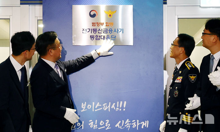 [서울=뉴시스] 박주성 기자 = 윤호중 행정안전부 장관이 15일 오후 서울 KT광화문 빌딩 WEST에서 열린 범정부 합동 전기통신금융사기 통합 대응단 개소식에서 현판 제막 후 현판을 만져보고 있다. 2025.10.15. park7691@newsis.com