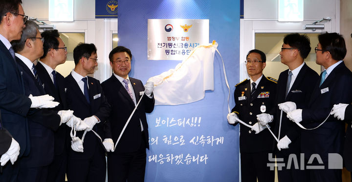 [서울=뉴시스] 박주성 기자 = 윤호중 행정안전부 장관과 유재성 경찰청장 직무대행을 비롯한 참석자들이 15일 오후 서울 KT광화문 빌딩 WEST에서 열린 범정부 합동 전기통신금융사기 통합 대응단 개소식에서 현판 제막을 하고 있다. 2025.10.15. park7691@newsis.com