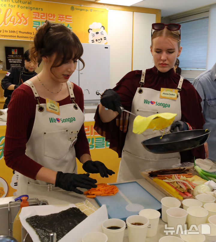 [서울=뉴시스] 김혜진 기자 = 15일 오후 서울 송파구 가락몰 도서관에서 열린 '코리안푸드 쿠킹클래스'에서 주한 외국인과 외국인 관광객들이 김밥을 만들고 있다. 2025.10.15. jini@newsis.com