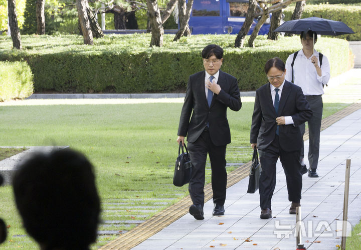[서울=뉴시스] 김근수 기자 = 이재근(왼쪽) SK그룹 최태원 회장 측 변호사가 16일 서울 서초구 대법원에서 열린 최 회장과 노 관장 간 이혼소송 상고심 선고 공판에 참석하기 위해 이동하고 있다. 2025.10.16. ks@newsis.com