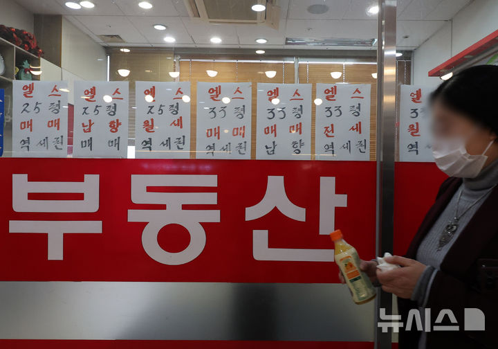 [서울=뉴시스] 배훈식 기자 = 정부의 '10·15 부동산 대책' 첫날인 16일 오후 서울 송파구의 한 공인중개사 사무소 앞을 시민이 지나가고 있다.  정부는 지난 15일 수도권·규제지역의 주택담보대출 한도를 주택 가격에 따라 기존 6억원에서 2억원까지 축소하는 내용의 '주택시장 안정화 대책'을 발표했다. 2025.10.16. dahora83@newsis.com