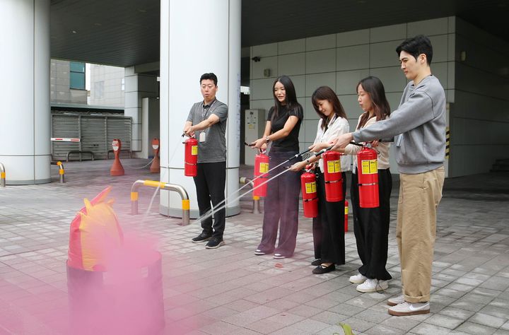[부산=뉴시스] 지난 16일 에어부산 사옥에서 임직원을 대상으로 산업재해 예방을 위해 비상대응 훈련을 실시했다. 임직원들이 소화기 사용법 및 진화 교육을 받고 있다. (사진=에어부산 제공) 2025.10.17. photo@newsis.com *재판매 및 DB 금지