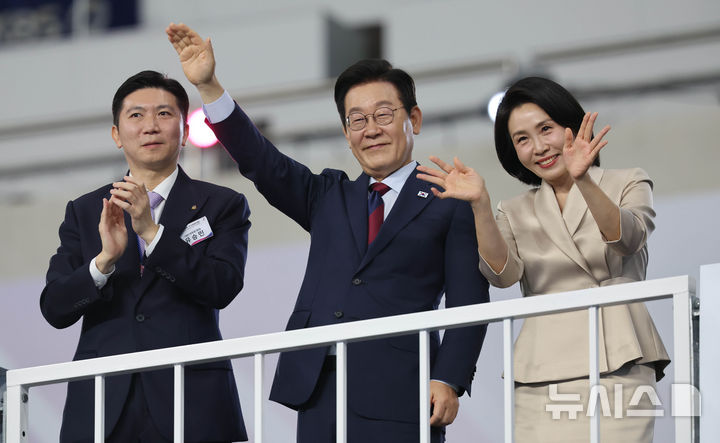 [부산=뉴시스] 황준선 기자 = 이재명 대통령과 김혜경 여사가 17일 오후 부산 연제구 부산아시아드주경기장에서 열린 제106회 전국체육대회 개회식에 참석해 입장하는 선수단을 환영하고 있다. 왼쪽은 유승민 대한체육회장. 2025.10.17. hwang@newsis.com