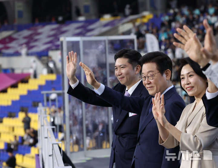 [서울=뉴시스] 최동준 기자 = 이재명 대통령과 김혜경 여사가 17일 부산아시아드주경기장에서 열린 제106회 전국체육대회 개막식에서 선수단 입장을 지켜보며 인사하고 있다. (대통령실통신사진기자단) 2025.10.17. photocdj@newsis.com