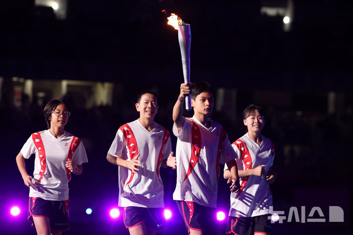 [부산=뉴시스] 황준선 기자 = 17일 오후 부산 연제구 부산아시아드주경기장에서 열린 제106회 전국체육대회 개회식에서 주자들이 성화를 봉송하고 있다. 2025.10.17. hwang@newsis.com
